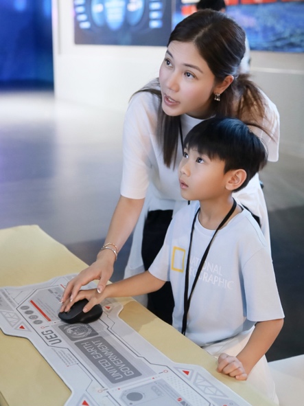 家長陪伴孩子體驗航天互動設施